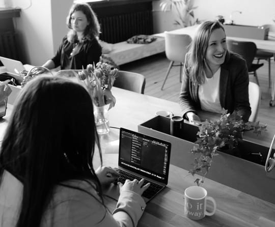 Image with a purple color overlay of three people in what seems to be an office