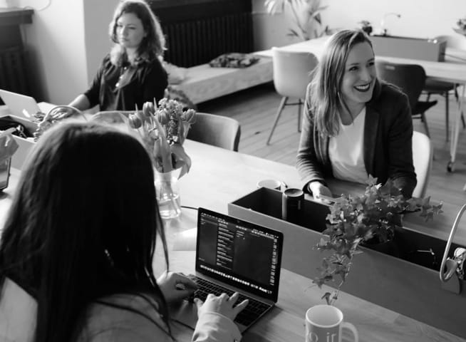 Image with a purple color overlay of three people in what seems to be an office